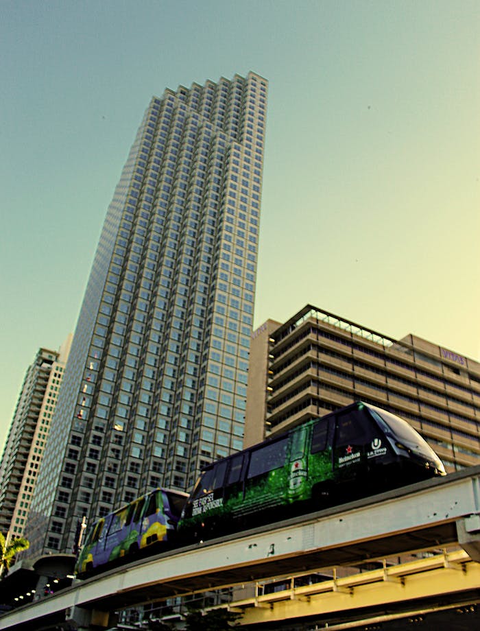 Contemporary skyscrapers with Miami Metromover in an urban cityscape during daylight.