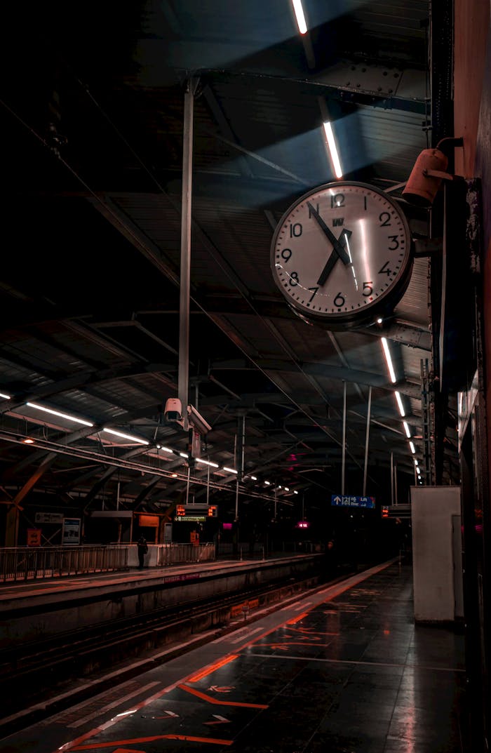 A serene nighttime view of Hyderabad's metro station featuring a prominent clock, evoking a calm urban atmosphere.